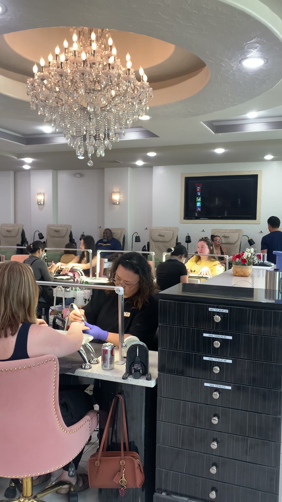 Clients in pink velvet chairs at the manicure bar